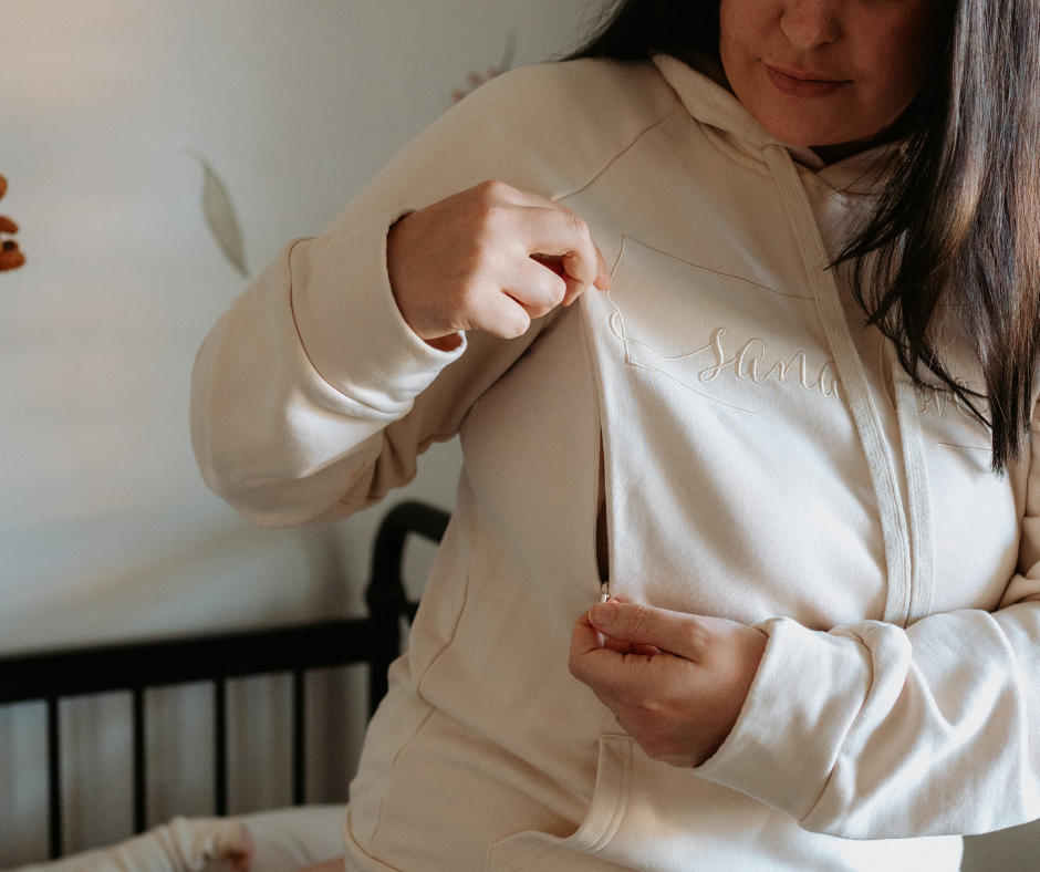 Woman unzipping breastfeeding hoodie. 