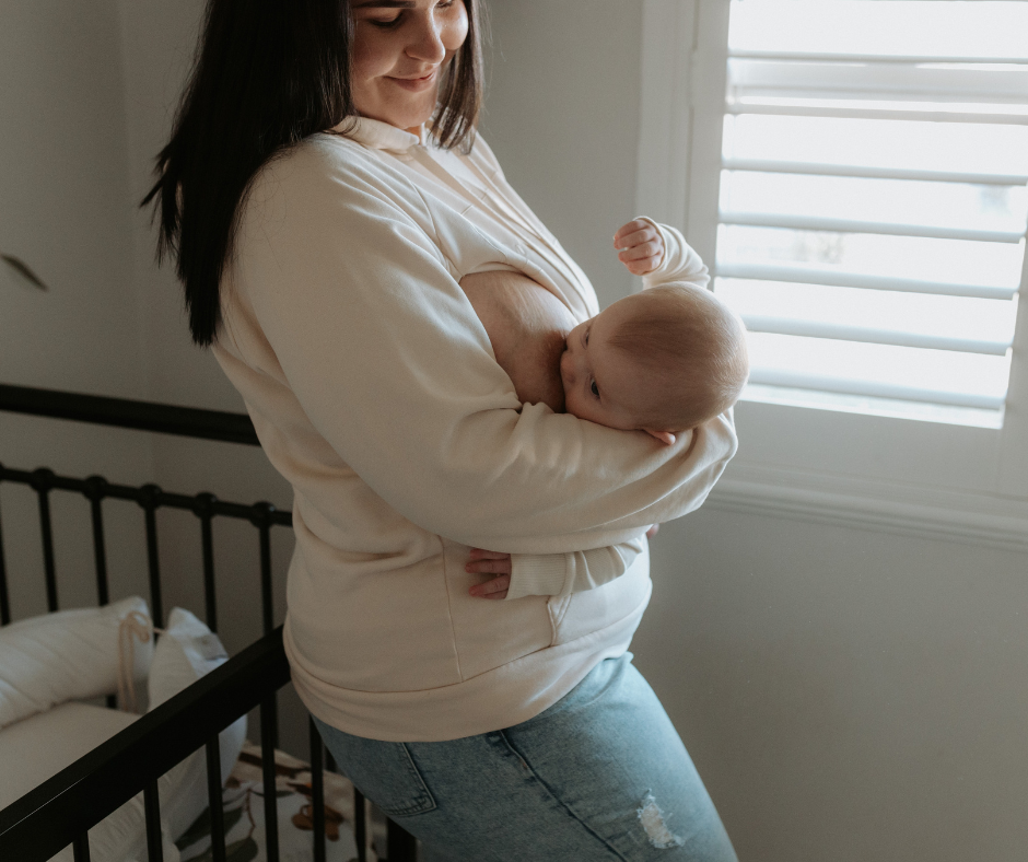 Woman breastfeeding baby in oatmeal nursing hoodie.